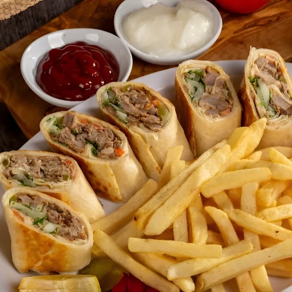 Tarbosh Mediterranean Restaurant's chicken shawarma wraps with french fries, ketchup, and garlic sauce.